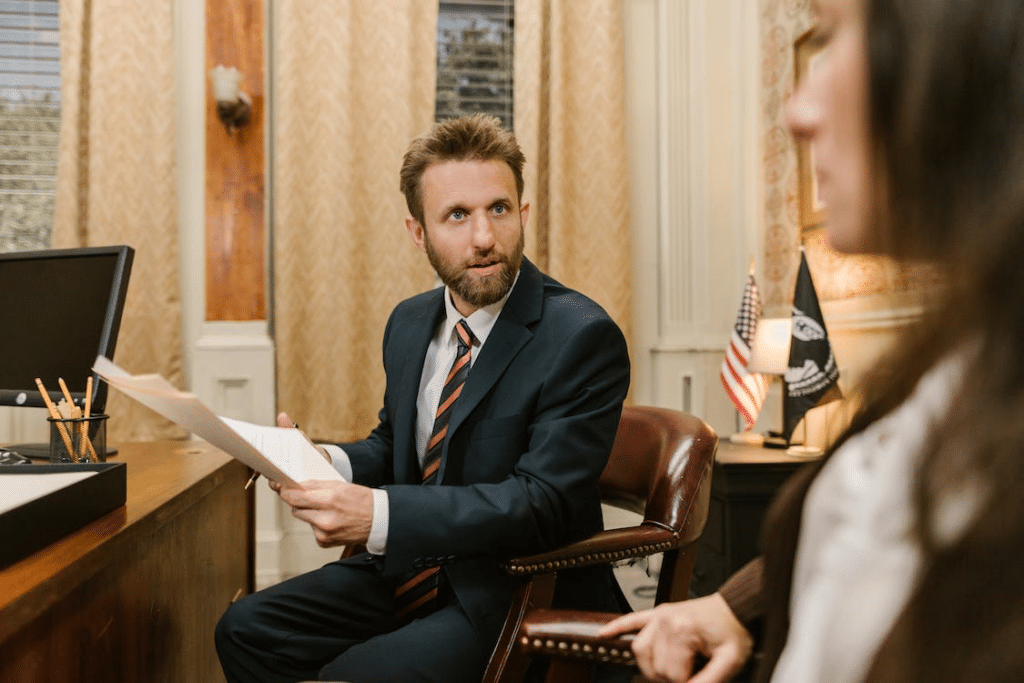a man in business suit holding a white paper while sitting on the grown chair