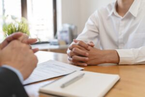 Employer or recruiter holding reading a resume during his profile of candidate, employer in suit is discussing to sign non-compete agreement