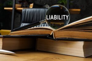 Liability - Law books and magnifying glass.