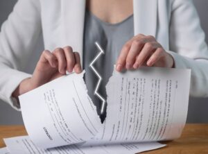 Torn contract in hands. Deal cancel. Sanctions, agreement conditions and terms violation consequences.