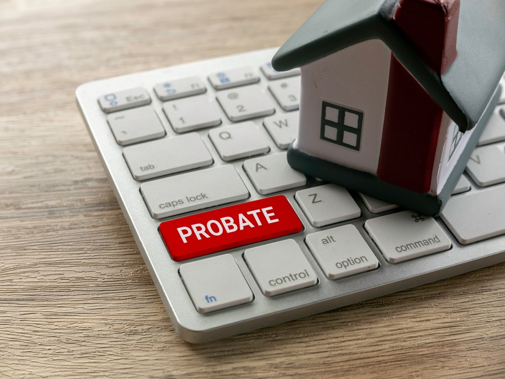Close-up of a keyboard with a red probate key and small house symbolizing Florida estate planning