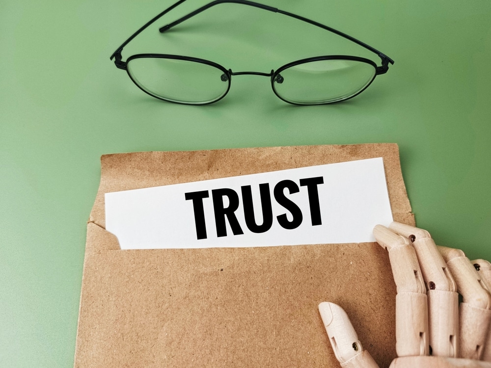 Envelope labeled trust with glasses and wooden hand, representing trust administration in Florida