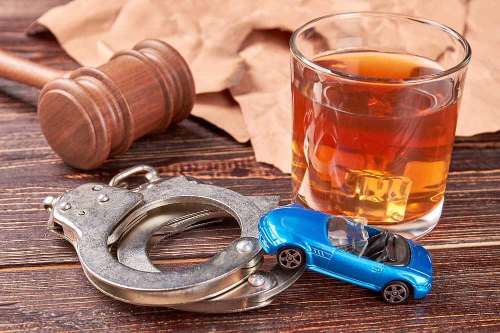 Gavel, handcuffs, car, whiskey, paper. 
