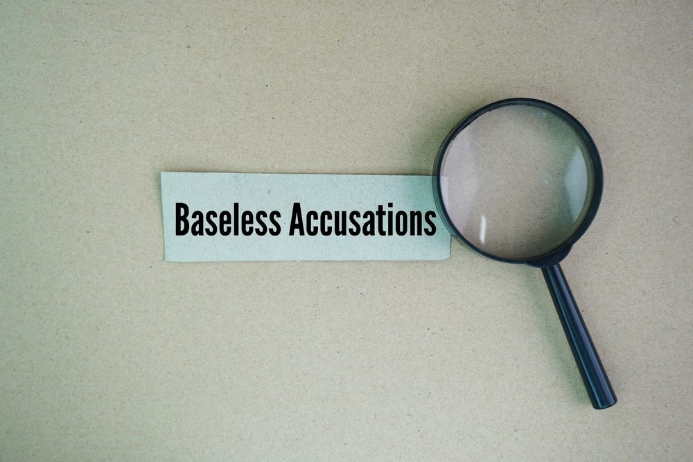 Magnifying glass over a paper reading "Baseless Accusations"